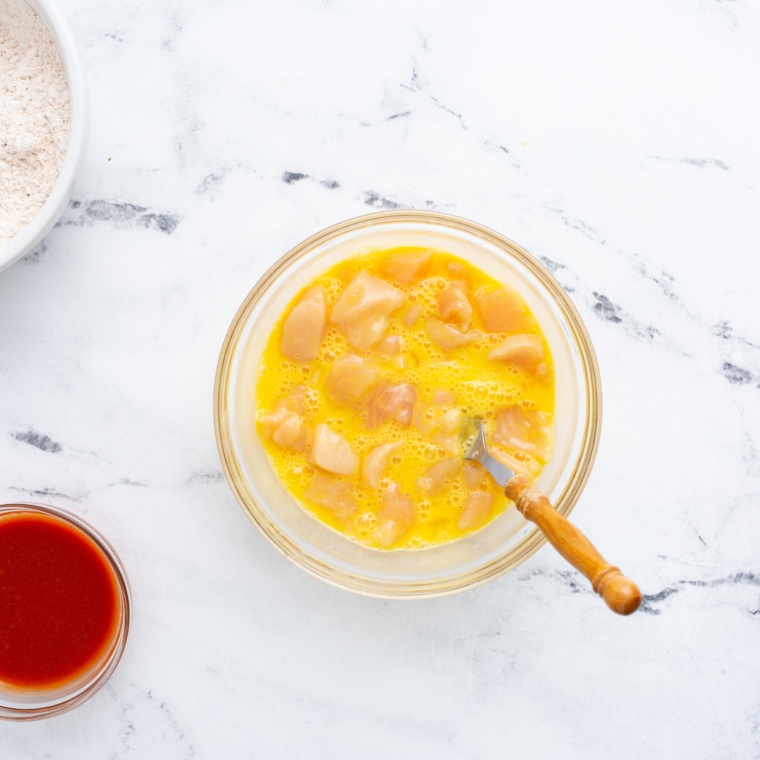 Bite-sized chicken pieces dredged in seasoned flour for air fryer Longhorn spicy chicken bites