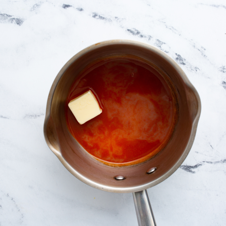Crispy chicken bites tossed in sweet-and-spicy honey hot sauce in a glass bowl