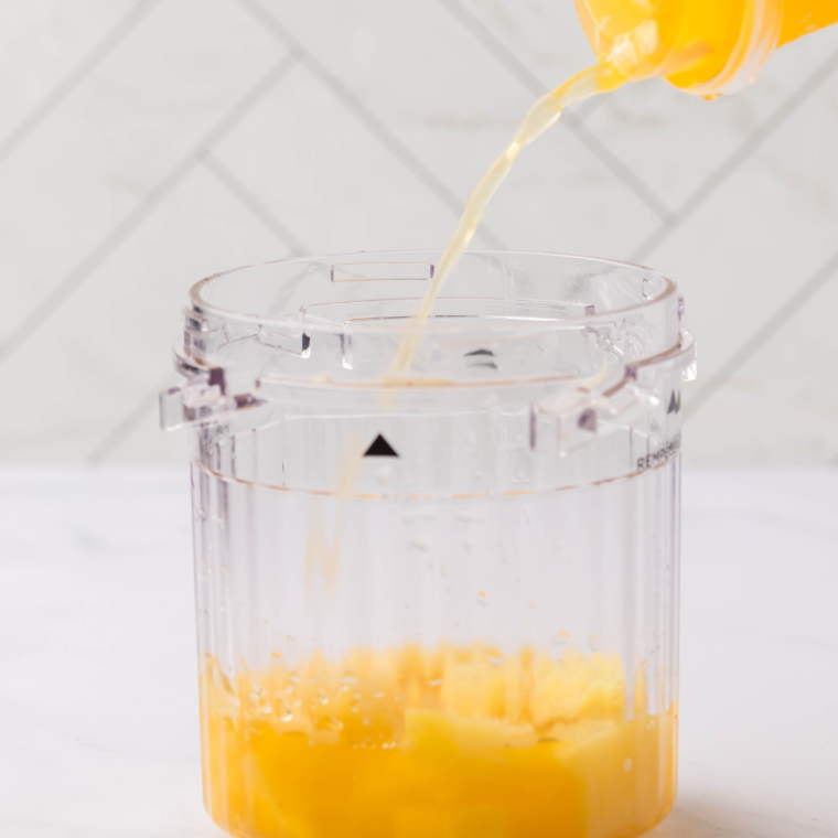 Pouring Starbucks Pineapple Passionfruit Lemonade into the Ninja Creami pint container