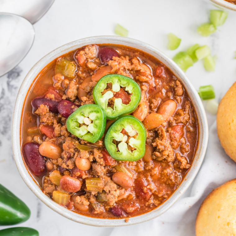 A bowl of homemade Panera-style turkey chili, garnished with fresh herbs and served with a side of crusty bread.