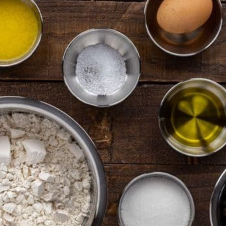 "Ingredients for Publix Breakfast Bread including flour, sugar, spices, butter, eggs, dried fruit, and nuts arranged on a countertop."