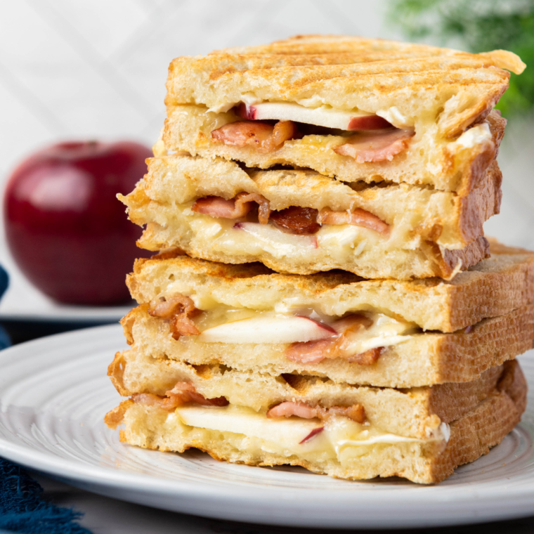 A 15-Minute Apple Brie Sandwich with crispy bacon, thinly sliced apples, and creamy Brie cheese, drizzled with honey.