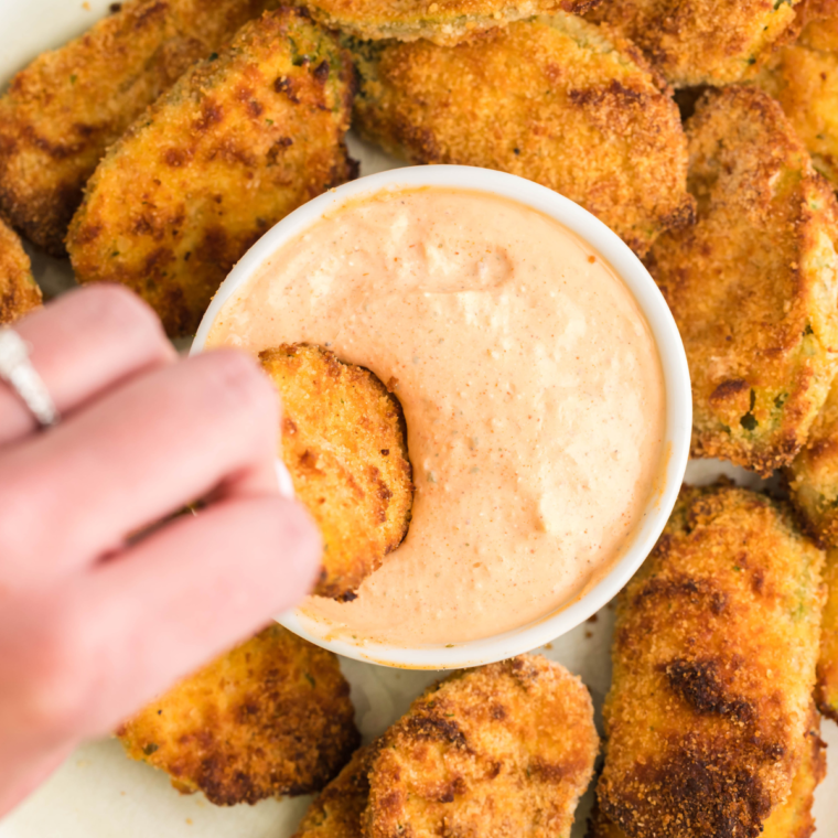 Crispy and golden air fryer pickle nickels, a copycat recipe of Red Robin’s famous appetizer, served with dipping sauce on a plate.