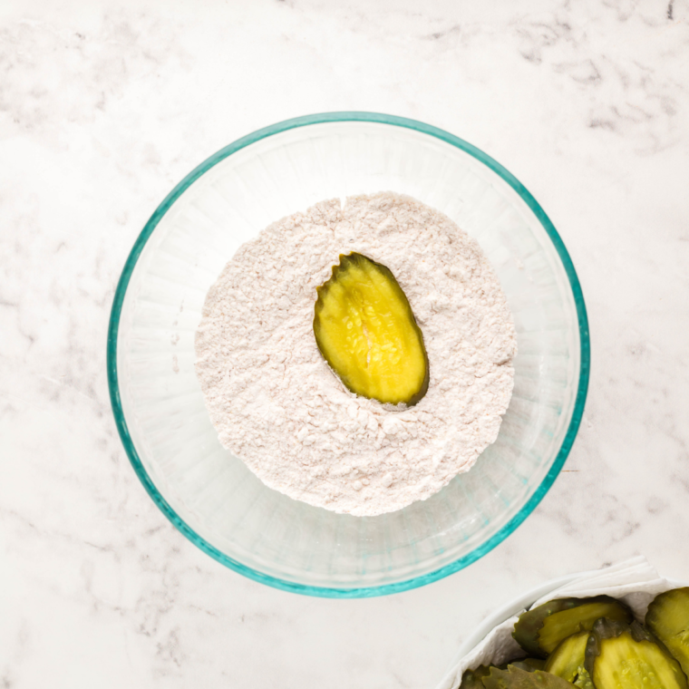 Paper towel patting pickle slices to remove moisture.