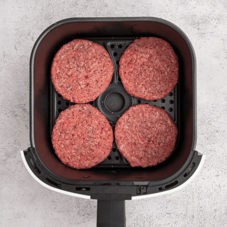 Preheating air fryer to 180°C (360°F) and forming seasoned burger patties from ground beef.
