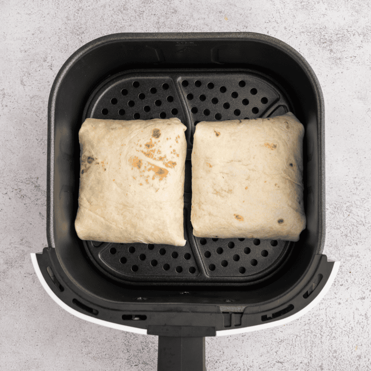 Air frying the wraps in the air fryer basket until the tortillas are crispy and golden brown at 180°C (360°F) for 2-3 minutes per side.
