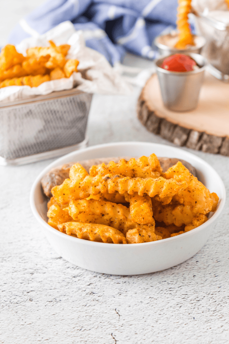 Homemade Red Robin Copycat French Fry Seasoning in a small bowl with measuring spoons
