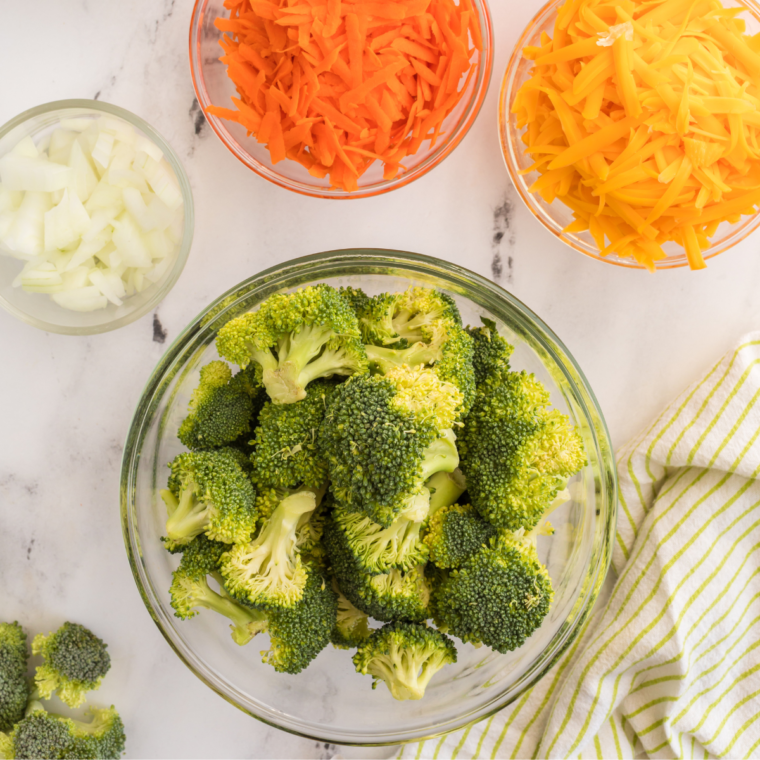 Fresh broccoli trimmed into evenly sized florets on a cutting board.