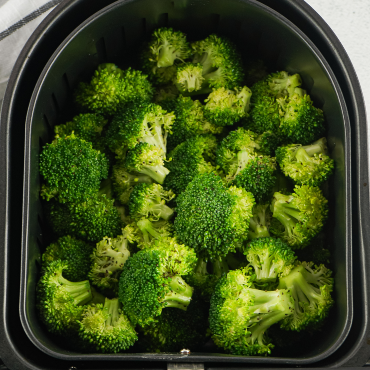 Broccoli florets steaming in a basket until bright green and crisp-tender.