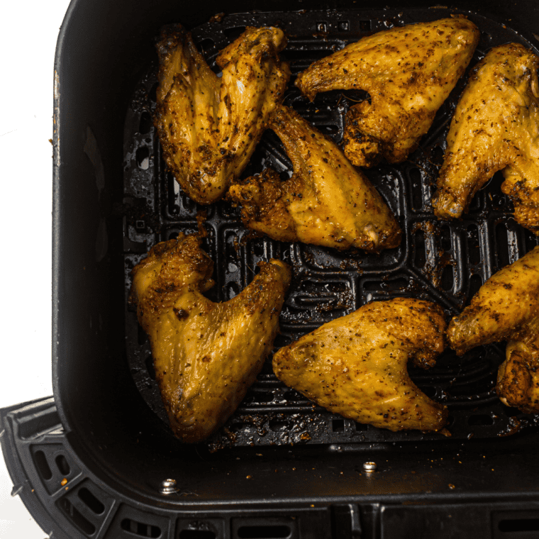 Butter melting in a small bowl mixed with lemon pepper seasoning, ready to coat the chicken wings.