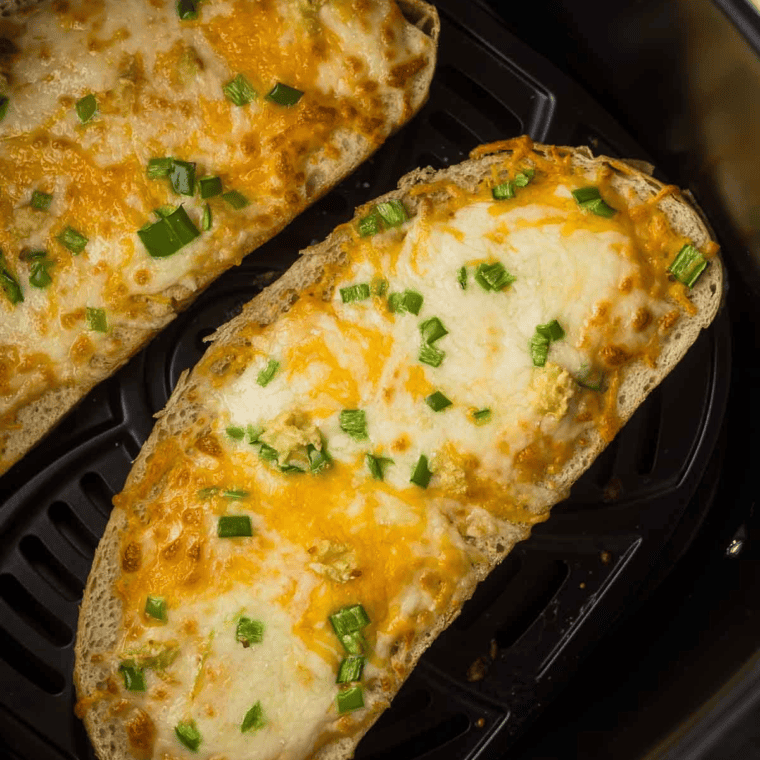 Close-up of crispy air fryer chile cheese toast with bubbly golden cheese and spicy chile peppers
