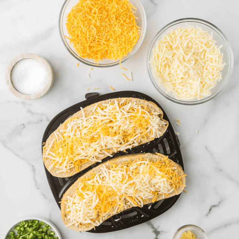 Grated cheddar and mozzarella sprinkled over buttered sourdough bread before air frying