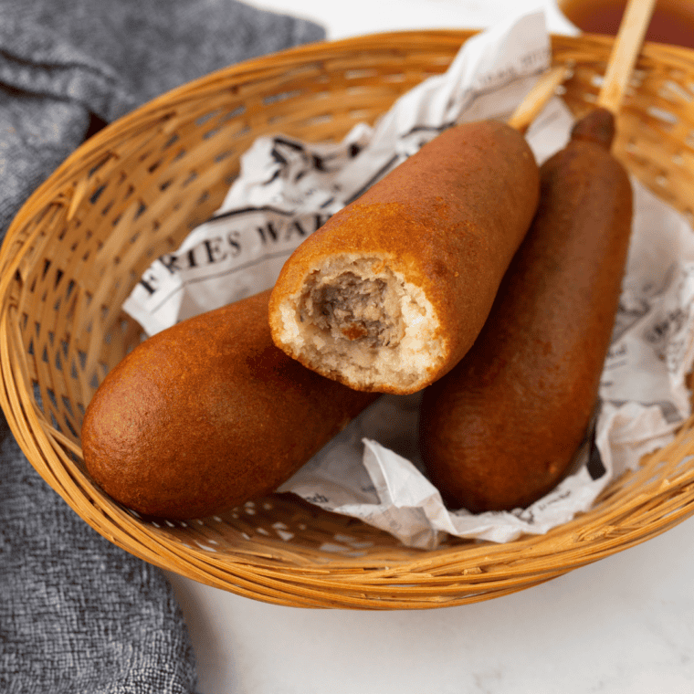 Frozen Jimmy Dean Pancakes and Sausage on a Stick in the air fryer basket for cooking.