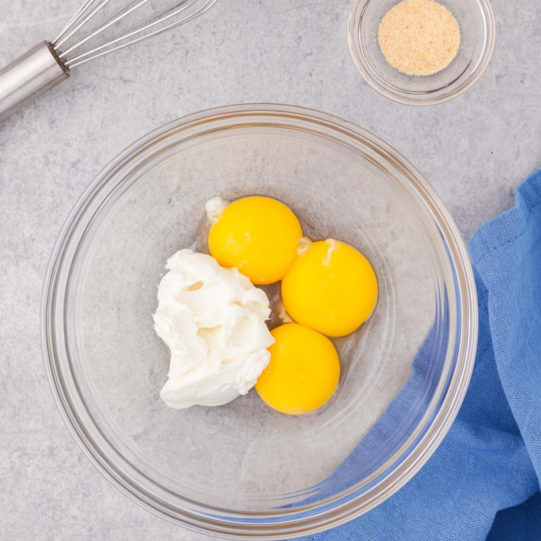 Preheating the air fryer to 300°F (150°C) while separating egg whites from yolks in a bowl to ensure fluffy cloud bread chips.