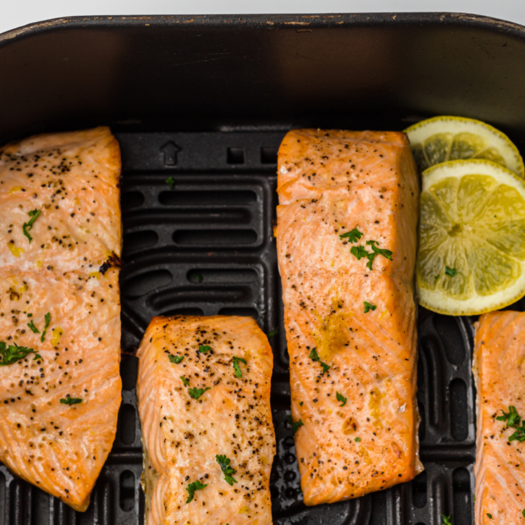 Healthy air fryer salmon bowl with crispy salmon and fresh veggies in a white bowl