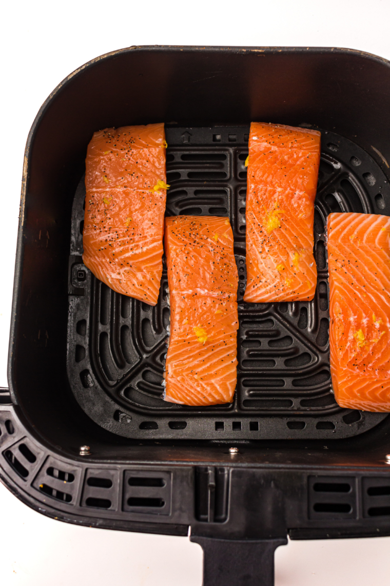 Salmon fillets in an air fryer basket at 400°F, skin-side down