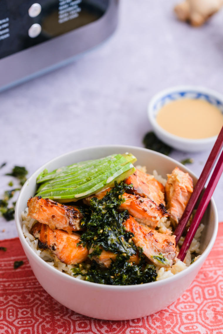 Close-up of a healthy salmon rice bowl with creamy avocado and crunchy cucumber