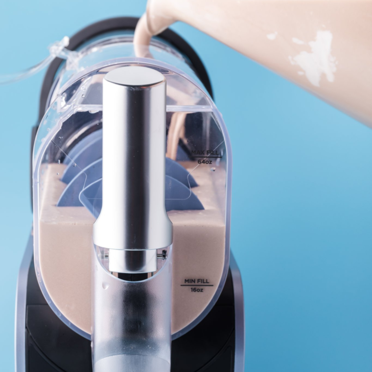Pouring mixture into Ninja Slushi Machine, selecting Milkshake button to churn and freeze.