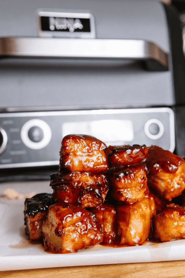 Tender and flavorful Ninja Smoked Pork Belly Burnt Ends, coated with steak rub, butter, brown sugar, and barbecue sauce for the ultimate smoky snack.