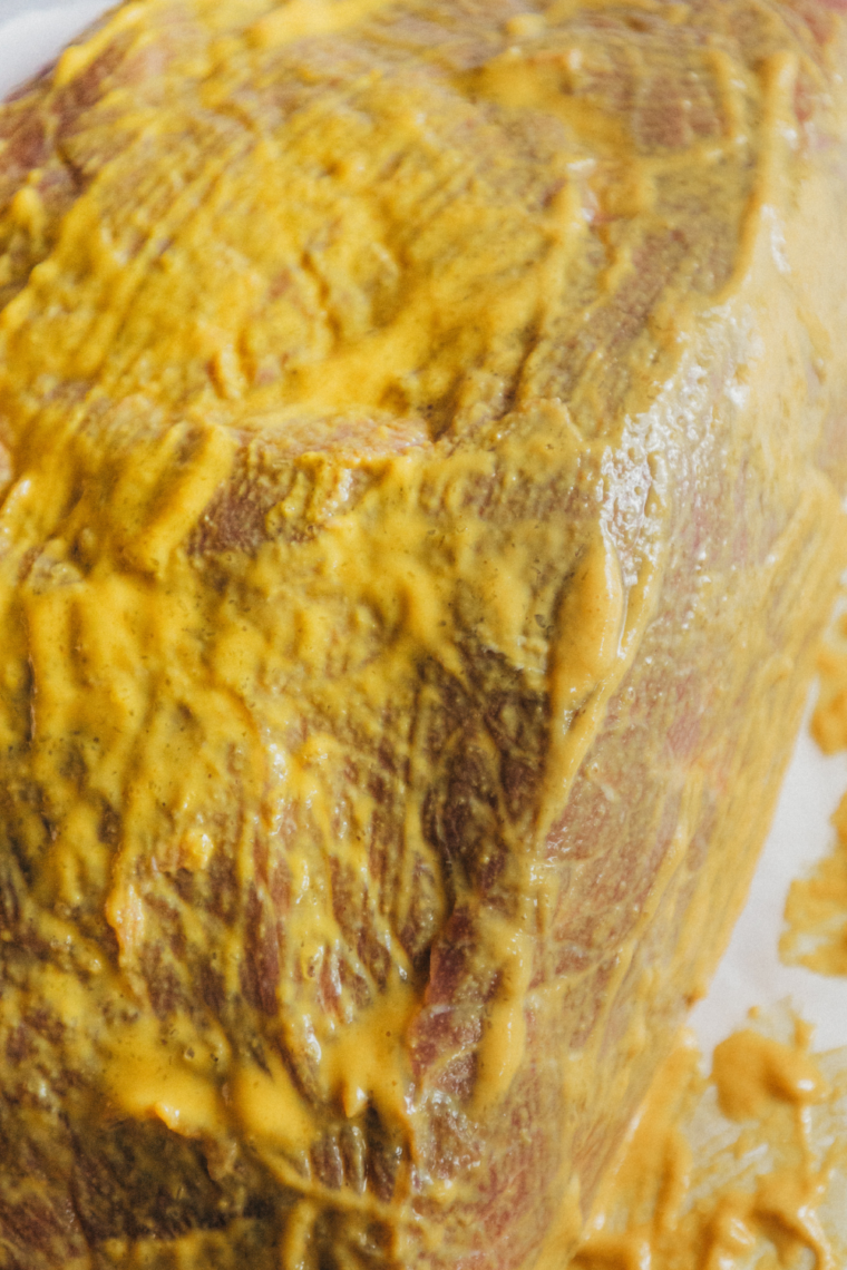 Coating the brisket with the rub.