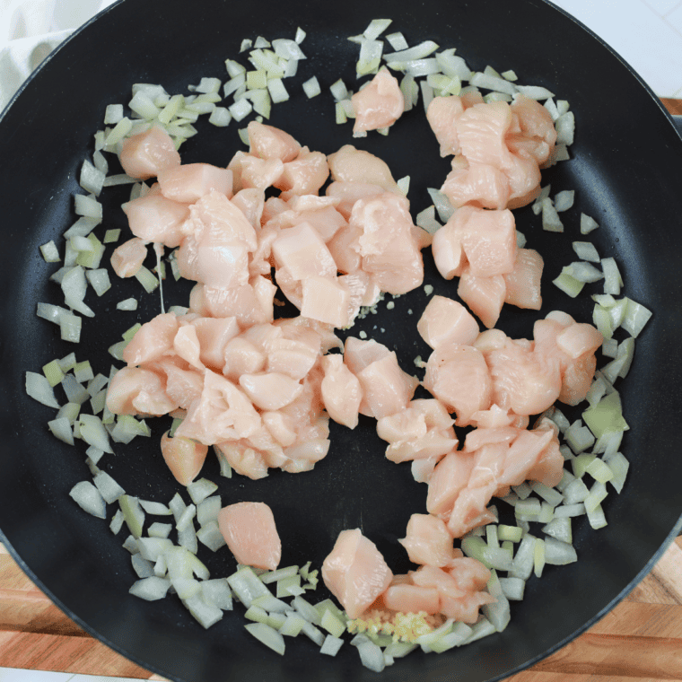 Diced onion sautéing in olive oil in a skillet