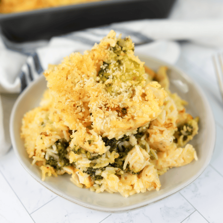 A scoop of broccoli cheese rice casserole with melted Velveeta and a crispy cracker topping