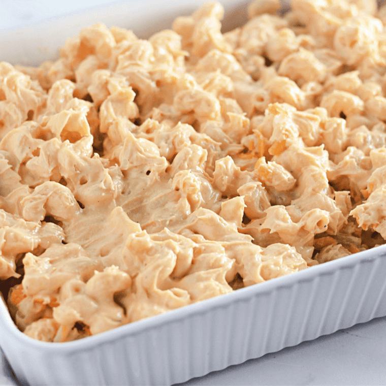 Transfer creamy mac and cheese to a greased baking dish, then sprinkle extra shredded cheddar and Monterey Jack on top for a cheesy finish.