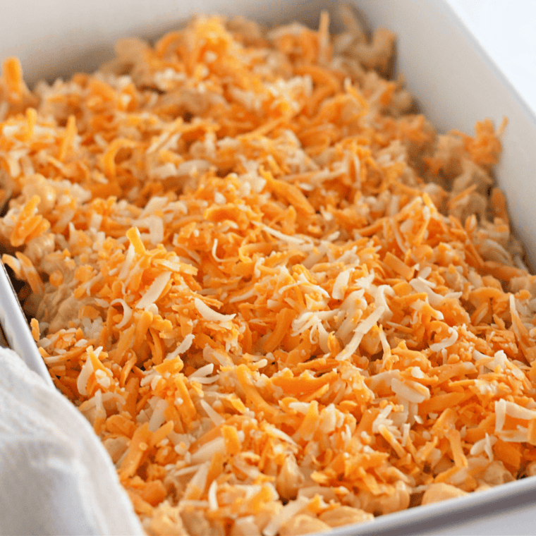 Sprinkling shredded cheddar and Monterey Jack on mac and cheese, then broiling until the top is bubbly and golden.