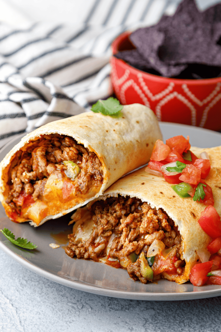 Crispy Air Fryer Beef Chimichangas filled with seasoned beef and melted cheese, served with salsa, guacamole, and sour cream.