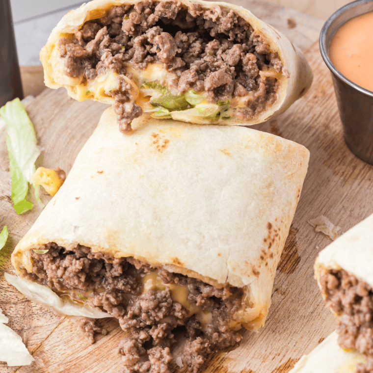 A crispy Air Fryer Big Mac Wrap filled with seasoned beef, melted cheese, lettuce, pickles, and special sauce, served on a plate.