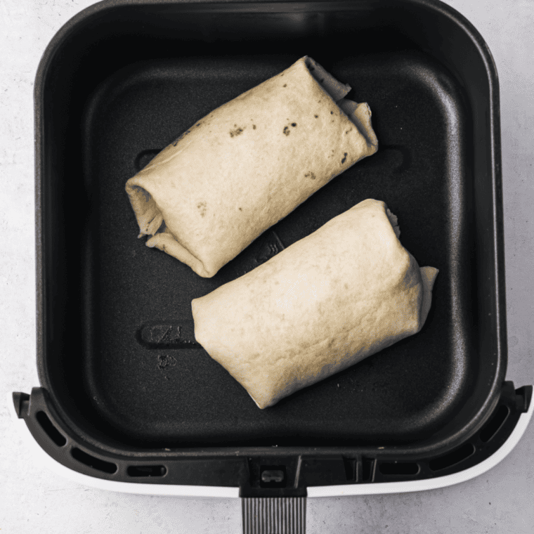 Rolling tortillas tightly, folding sides to secure beef and fillings.