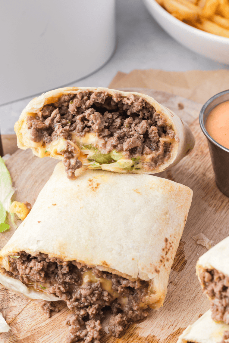 Crispy Air Fryer Big Mac Wraps filled with seasoned beef, melted cheese, lettuce, onions, pickles, and special sauce, served on a plate.