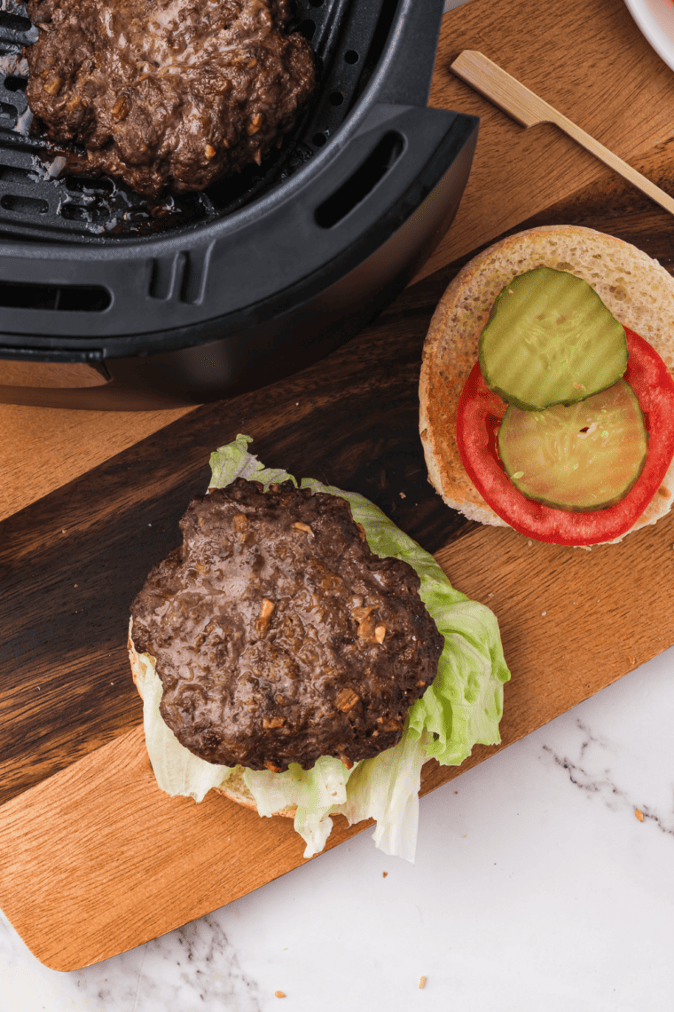 Air Fryer Lipton Onion Soup Mix Burger patties cooking in the air fryer basket, golden and crispy.
