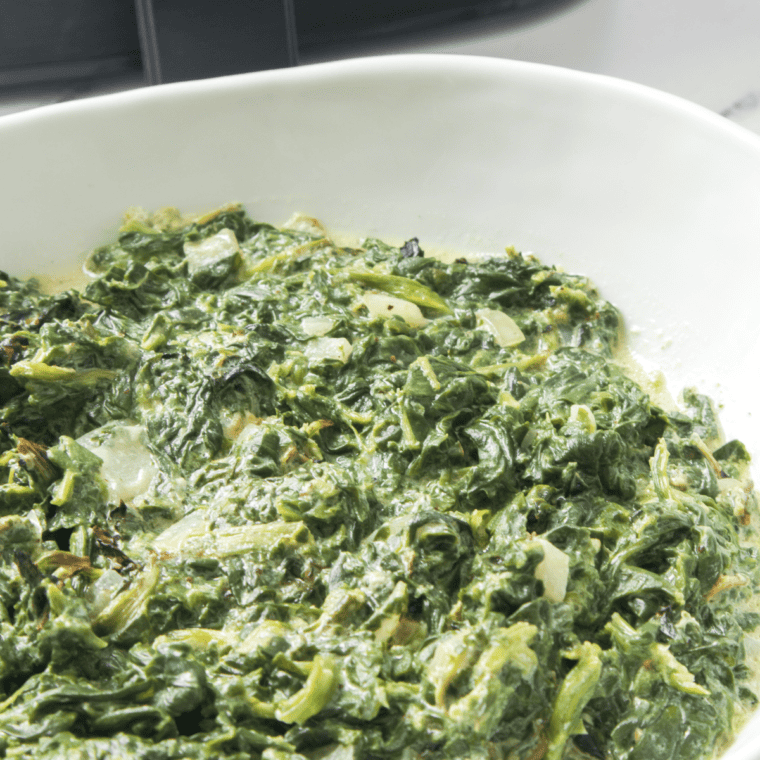 A creamy bowl of Easy Creamed Spinach, made with fresh spinach, garlic, cream cheese, and Parmesan, ready to serve.