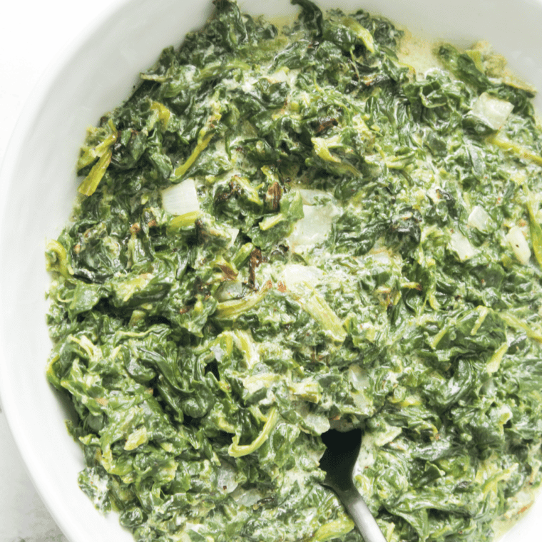 A creamy bowl of Easy Creamed Spinach, made with fresh spinach, garlic, cream cheese, and Parmesan cheese.