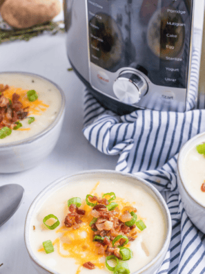 Instant Pot Panera Baked Potato Soup topped with crispy bacon, shredded cheese, and green onions.