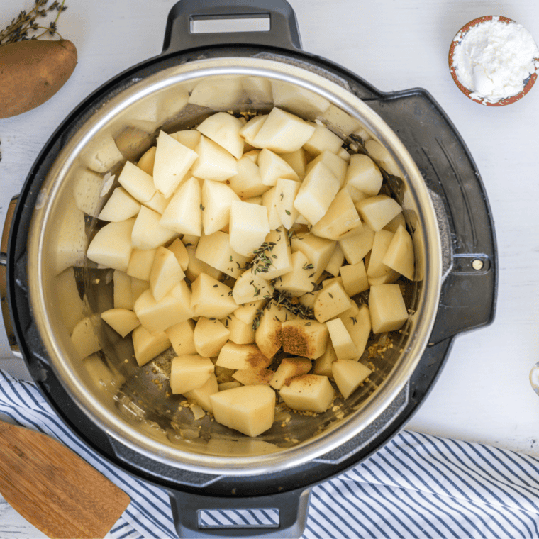 Adding diced Yukon potatoes, seasonings, and bacon bits to the pot.