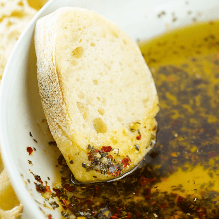 Homemade Johnny Carino's Olive Oil Dip made with olive oil, balsamic vinegar, and herbs.