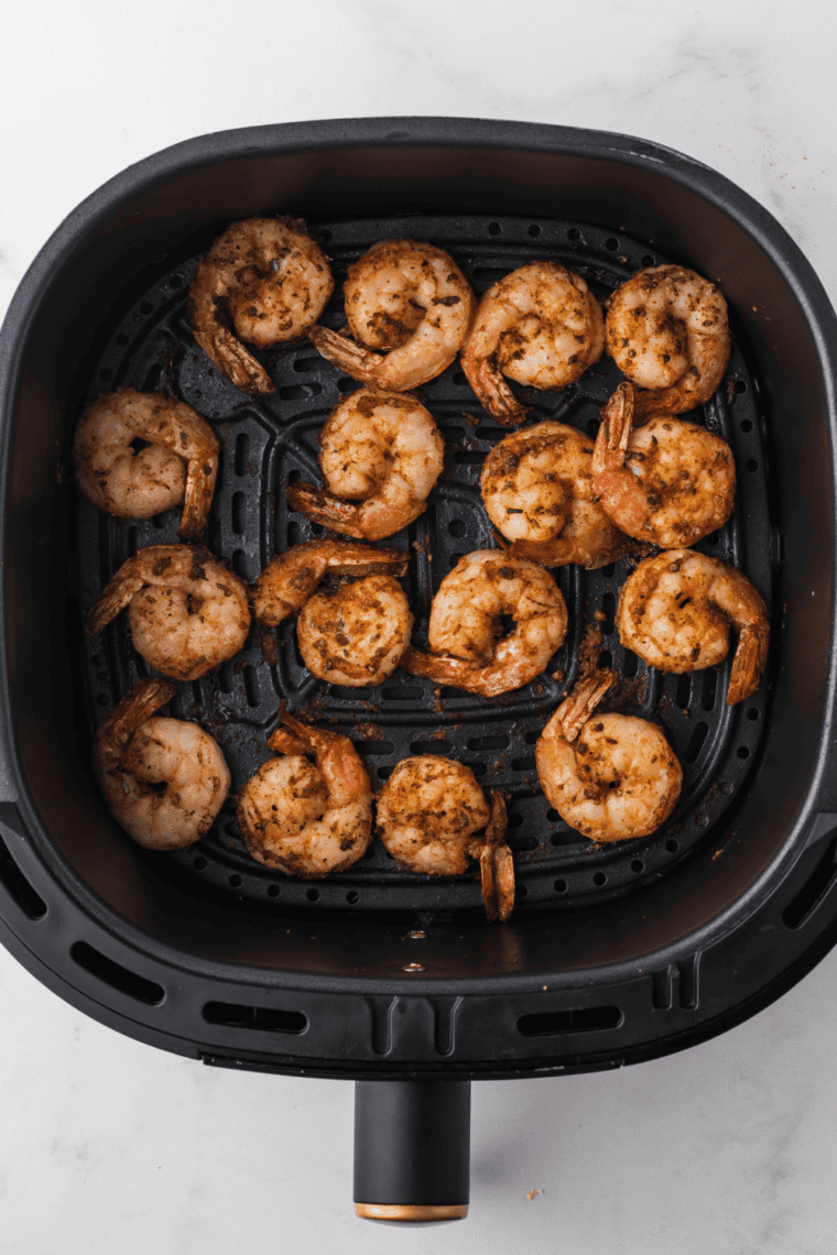 Seasoned Redrock shrimp arranged in a single layer in the air fryer basket