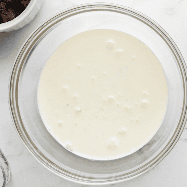 Slowly pour in heavy cream and whole milk, stirring until smooth.