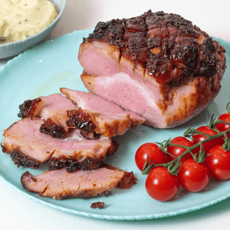 Air fryer gammon joint with a golden, caramelized glaze, sliced and ready to serve on a cutting board