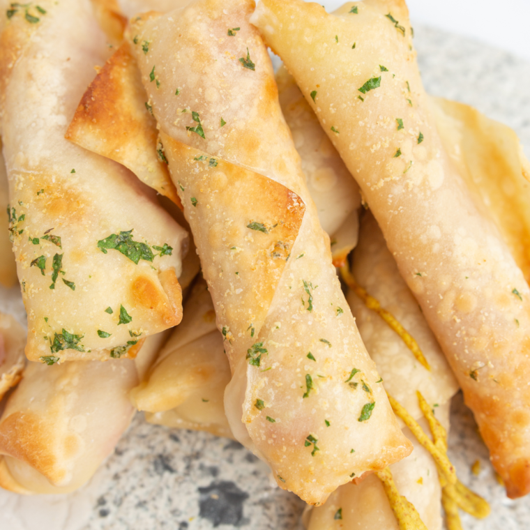 Air Fryer Ham and Mozzarella Cheese Sticks with a crispy golden coating and melted cheese inside, served with a dipping sauce.