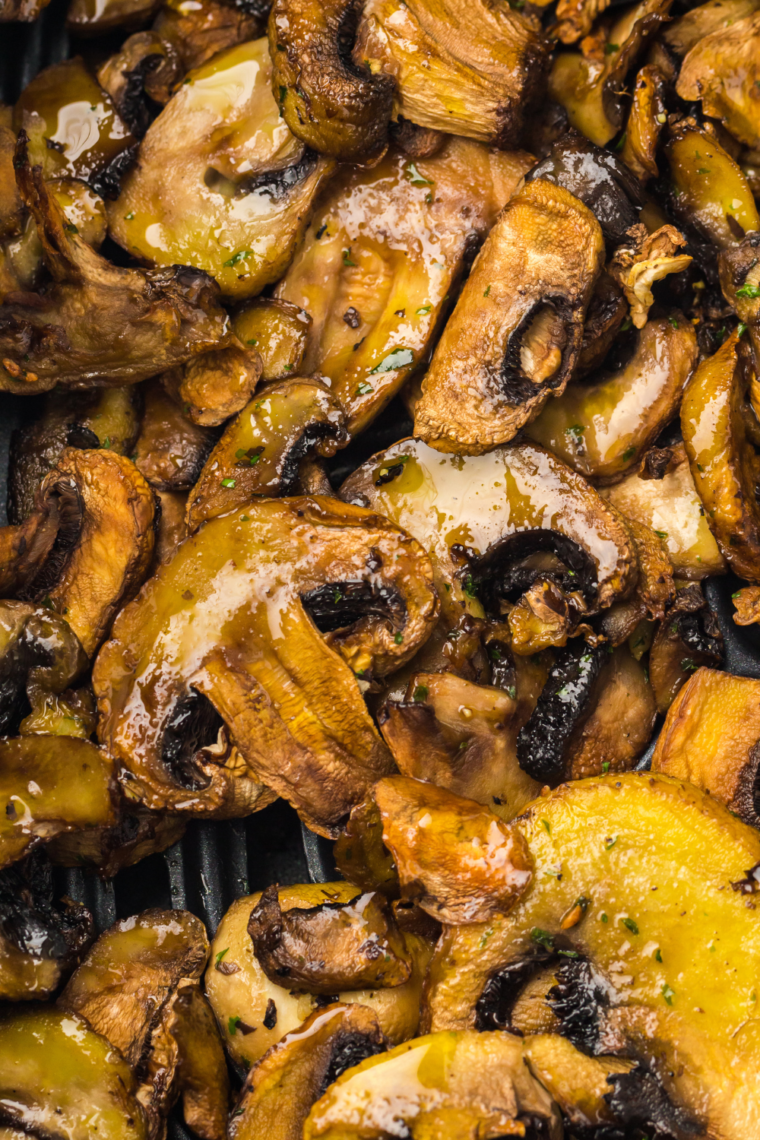 Bread slices brushed with olive oil toasting in the air fryer until golden and crispy.