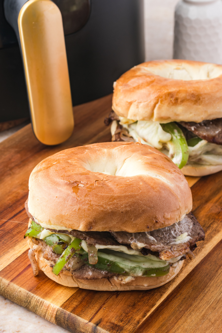 Air Fryer Philly Cheesesteak Bagel Sandwich with steak, bell peppers, onions, and melted provolone cheese on a toasted bagel.