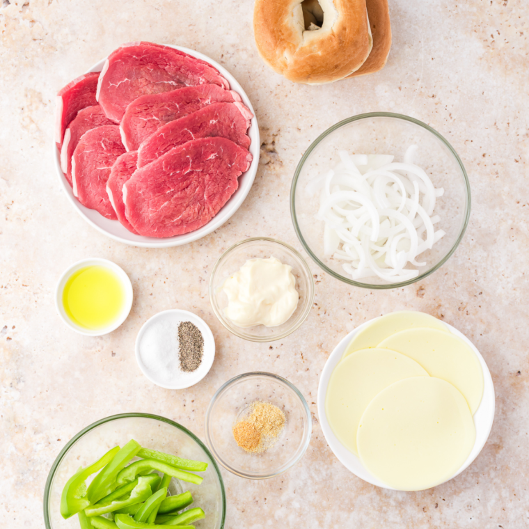 Ingredients needed for Air Fryer Philly Cheesesteak Bagel Sandwich on kitchen table.