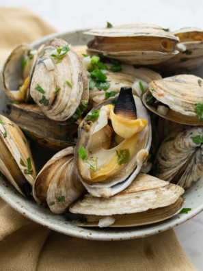Steamed clams cooked in the air fryer with garlic, butter, and herbs in a foil packet