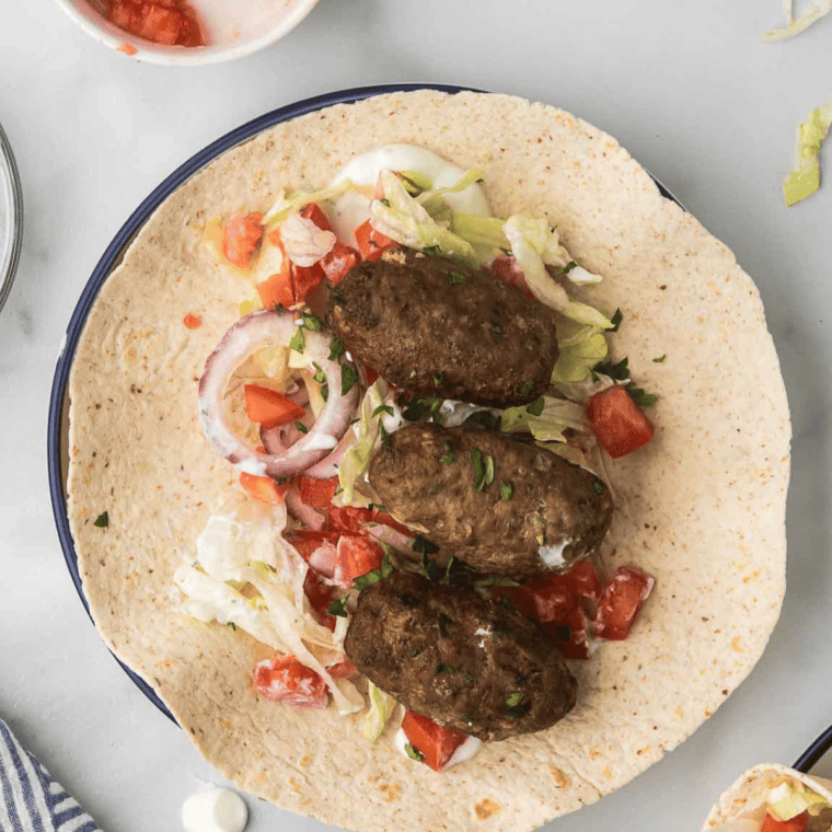 Turkish lamb wrap made in the air fryer, filled with spiced ground lamb, fresh vegetables, and yogurt sauce in soft flatbread.