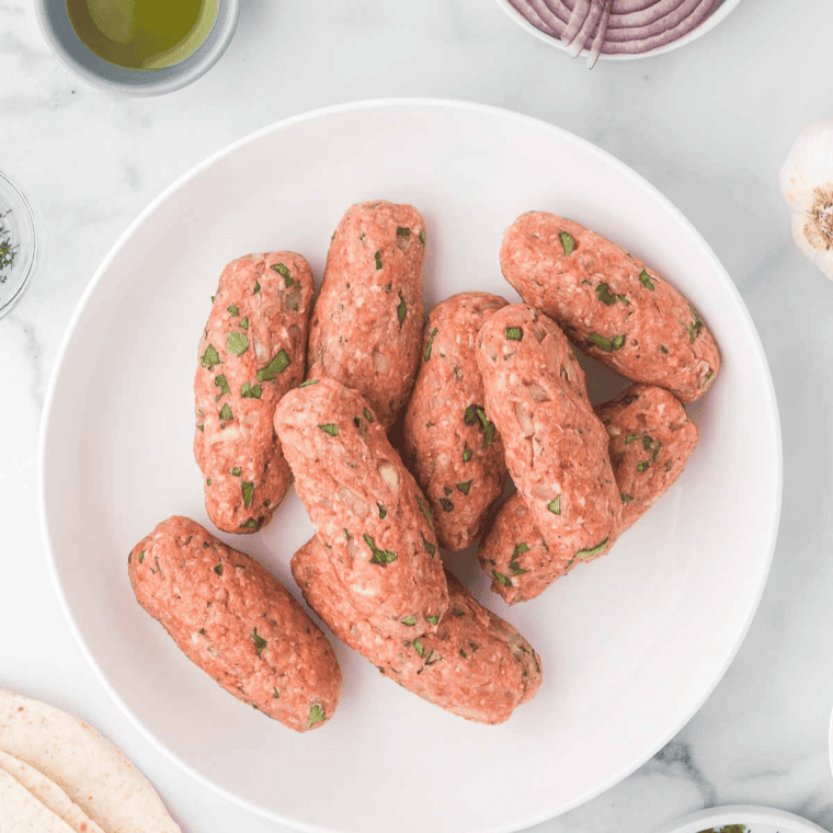 Small lamb patties or crumbled mixture placed in an air fryer basket.