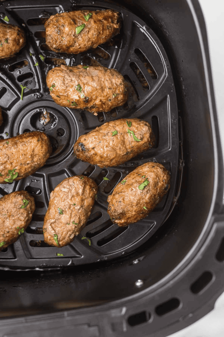 Cooked lamb in the air fryer basket.