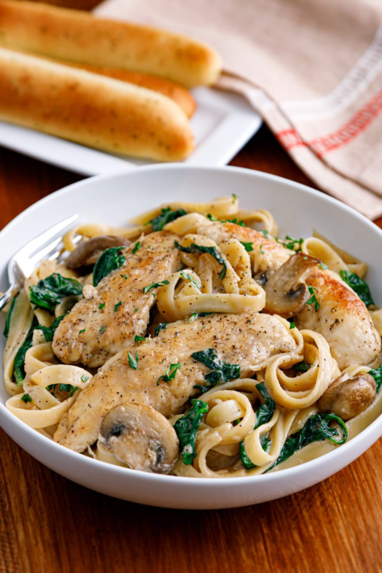 Barefoot Contessa Chicken Marsala served in a white bowl with mushrooms and fresh parsley.